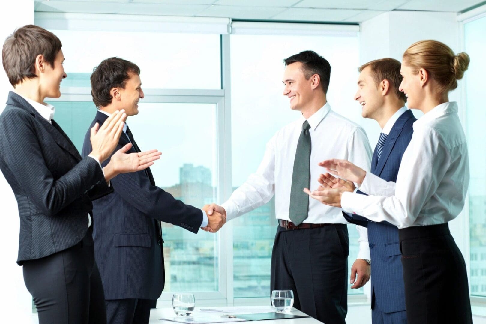 A group of people standing around shaking hands.