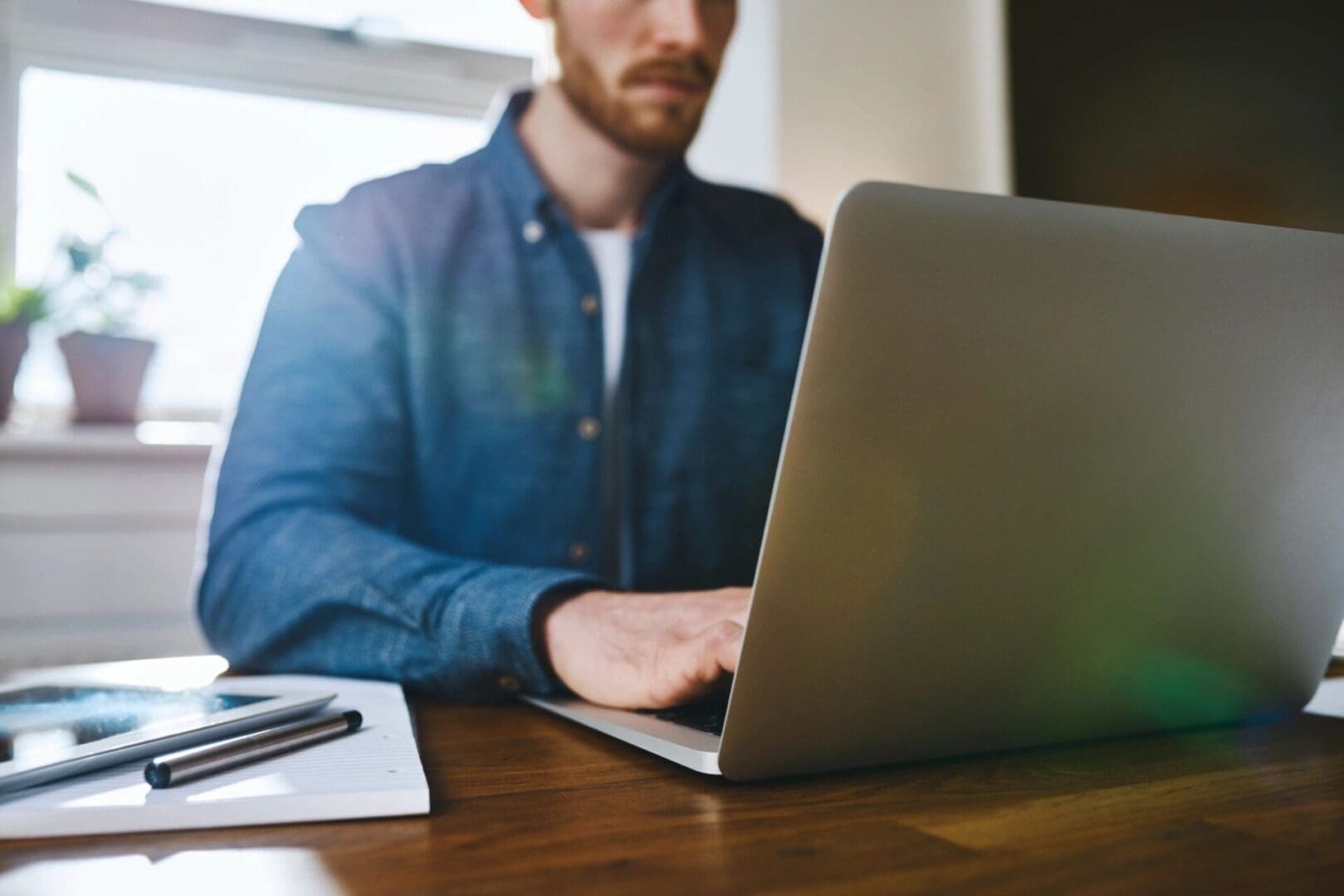 A man sitting at a table with a laptop.